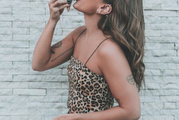woman in an animal print top licking an ice cream cone