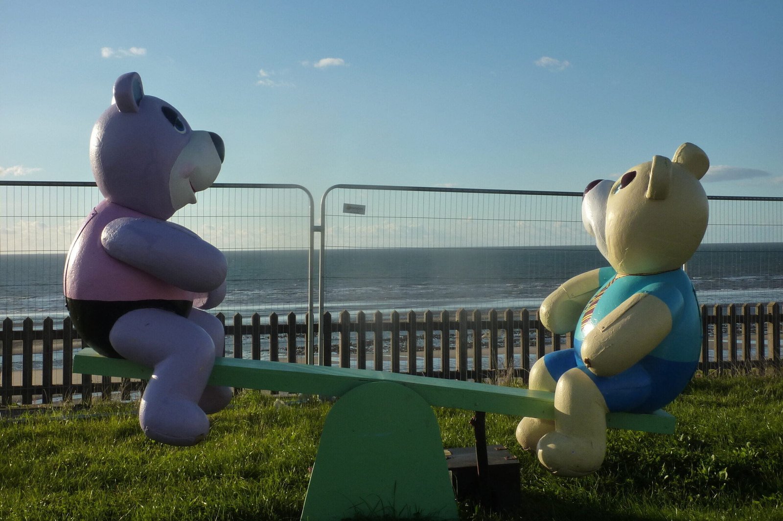 Two bears on a swing beside Blackpool Beach