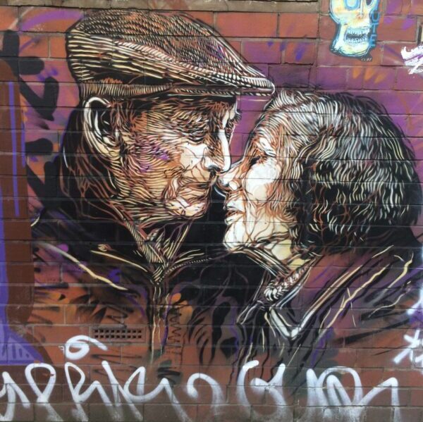 street art of elderly man and woman about to kiss