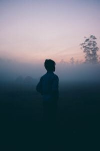 a shadow of a person standing in a very misty scene