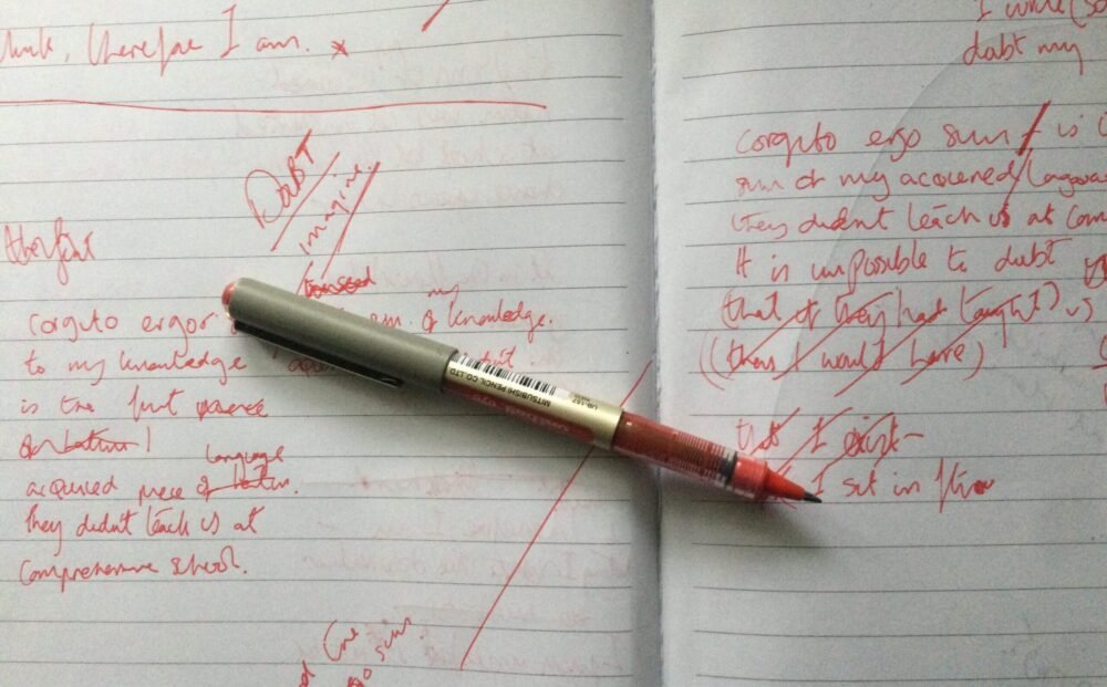 a notebook filled with notes and a red ballpoint pen