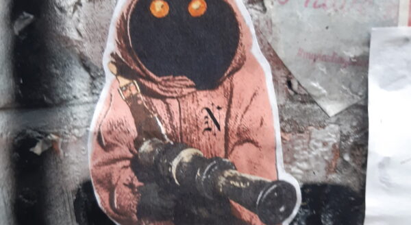 a ghoul in an orange hooded jacket holding a gun
