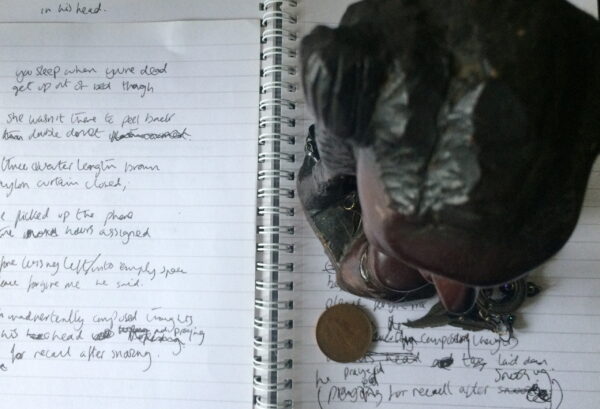 a scribbled notedpad with a statue on it with a two pence piece