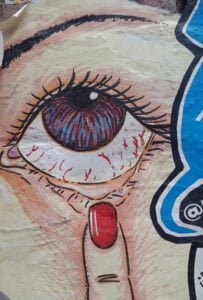 street art of an a ladies finger pointing to her eye