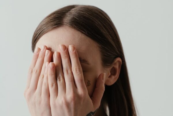 woman covering her face with her hands