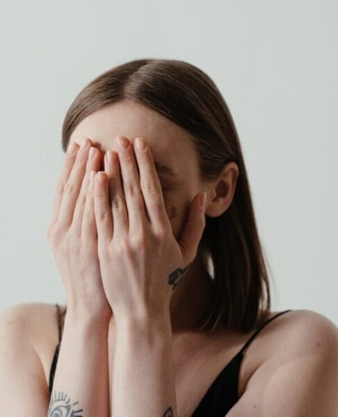 woman covering her face with her hands