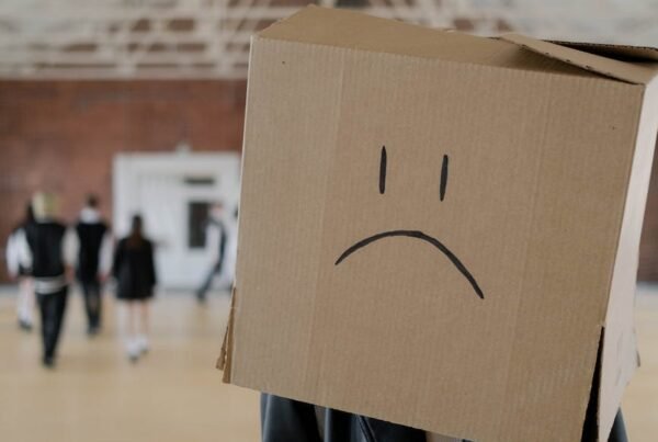 brown cardboard box with sad face