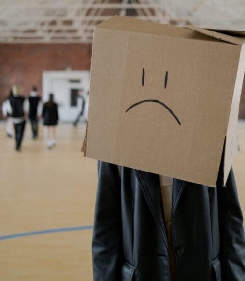 brown cardboard box with sad face