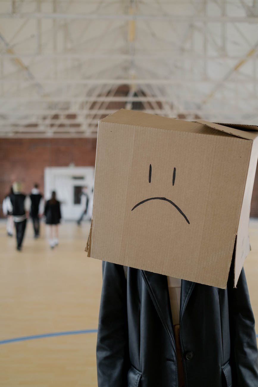 brown cardboard box with sad face