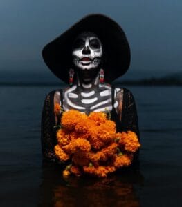 woman with a skeleton body paint holding flowers
