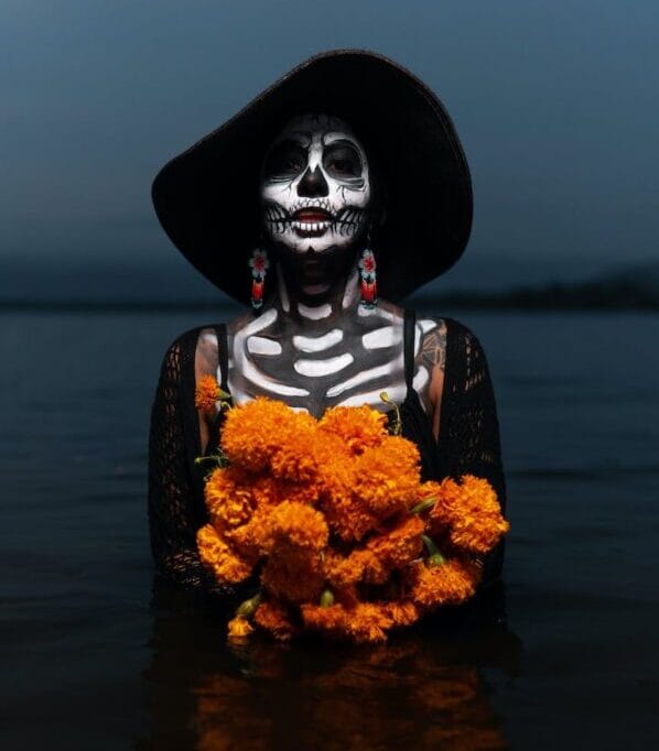 woman with a skeleton body paint holding flowers