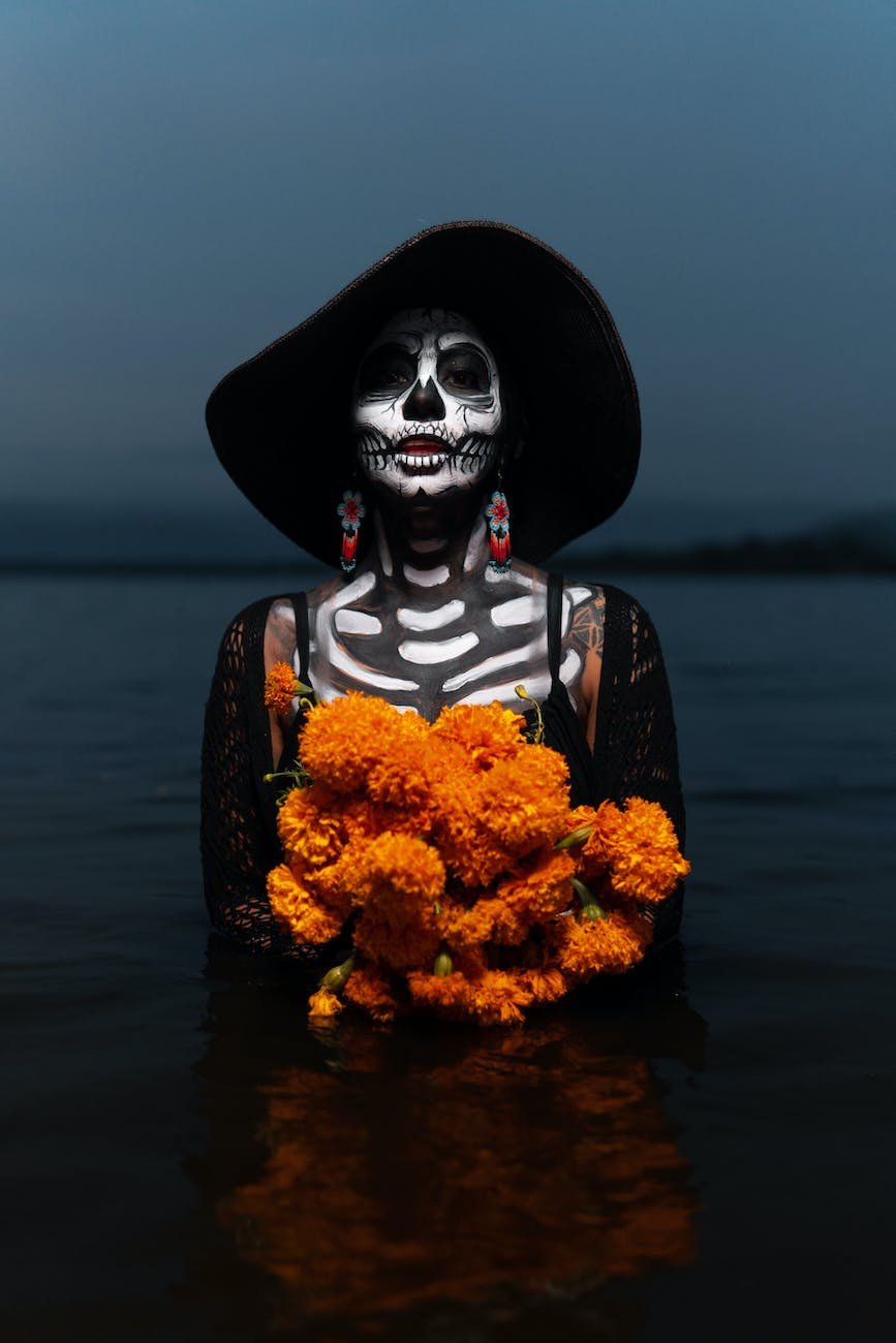 woman with a skeleton body paint holding flowers