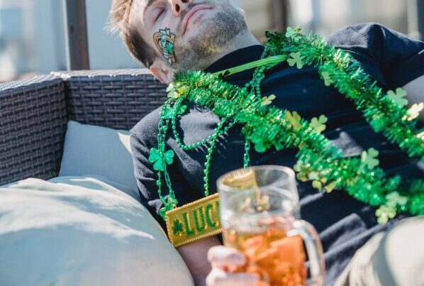 drunk man with beer glass sleeping on couch after hangout