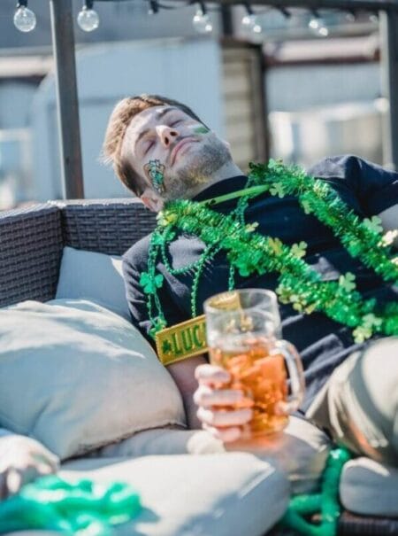 drunk man with beer glass sleeping on couch after hangout