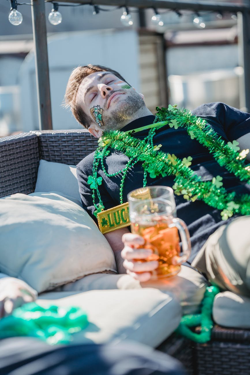 drunk man with beer glass sleeping on couch after hangout