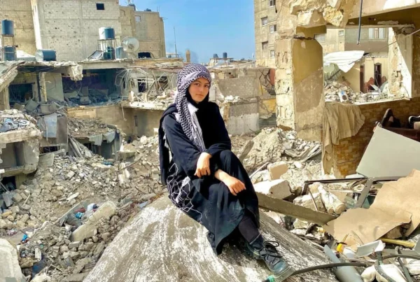 A young woman in Gaza sitting amidst rubble