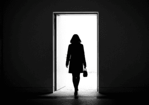 Mminimalist silhouette of a woman leaving a dark room, positioned in an open doorway. 
