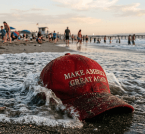 Wet "MAGA" cap washed ashore on a busy beach.