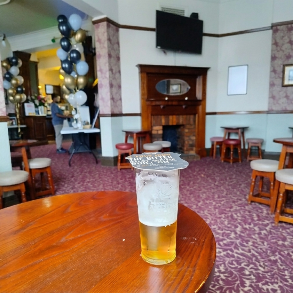 A beer glass with a coaster on at The Claremont, Moss Side, Manchester.